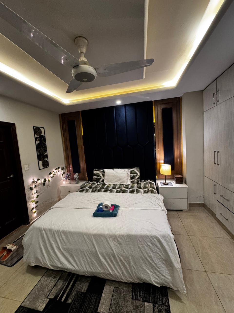 Main bedroom prepared with fresh towels before a guest arrival at the Aangan three-bedroom apartment in E-11, Islamabad