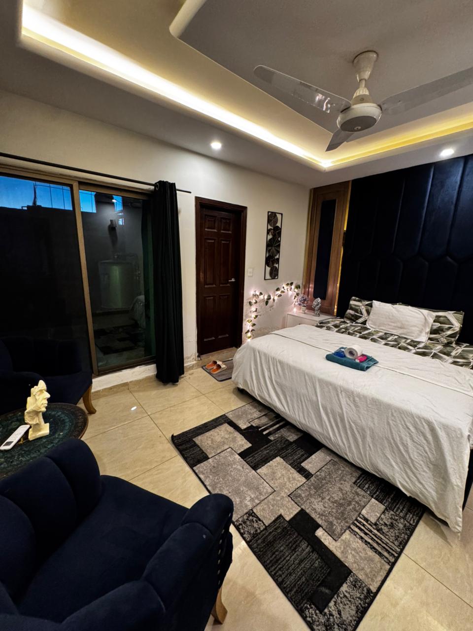 Seating area with armchairs beside the balcony door in the main bedroom of the Aangan three-bedroom apartment in E-11, Islamabad