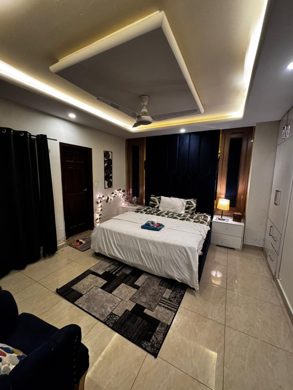 Main bedroom with a king bed, built-in wardrobe and rug in the Aangan three-bedroom apartment in E-11, Islamabad