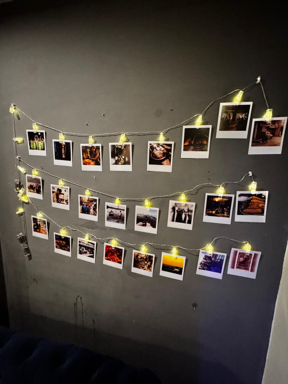 Photo wall with string lights in the living room of the Aangan three-bedroom apartment in E-11, Islamabad