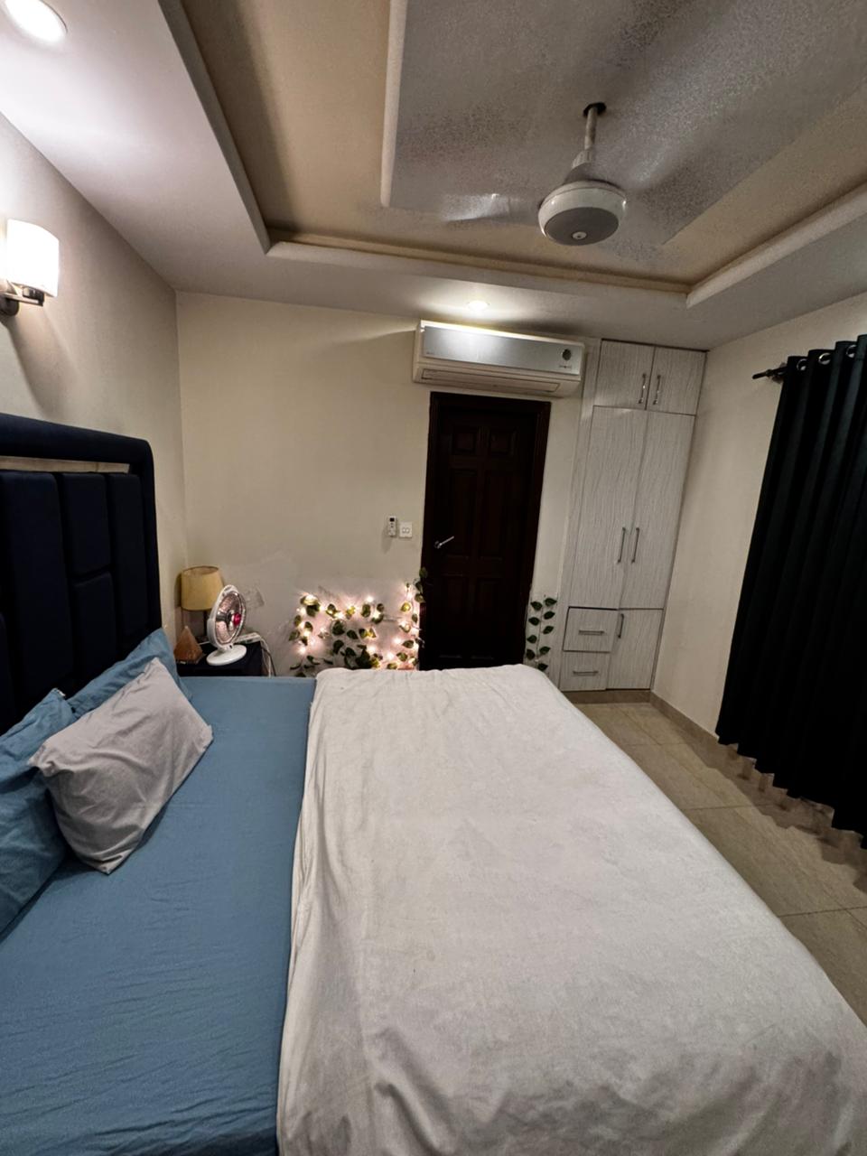 Bedroom with a double bed, built-in wardrobe and air conditioning in the Aangan three-bedroom apartment in E-11, Islamabad