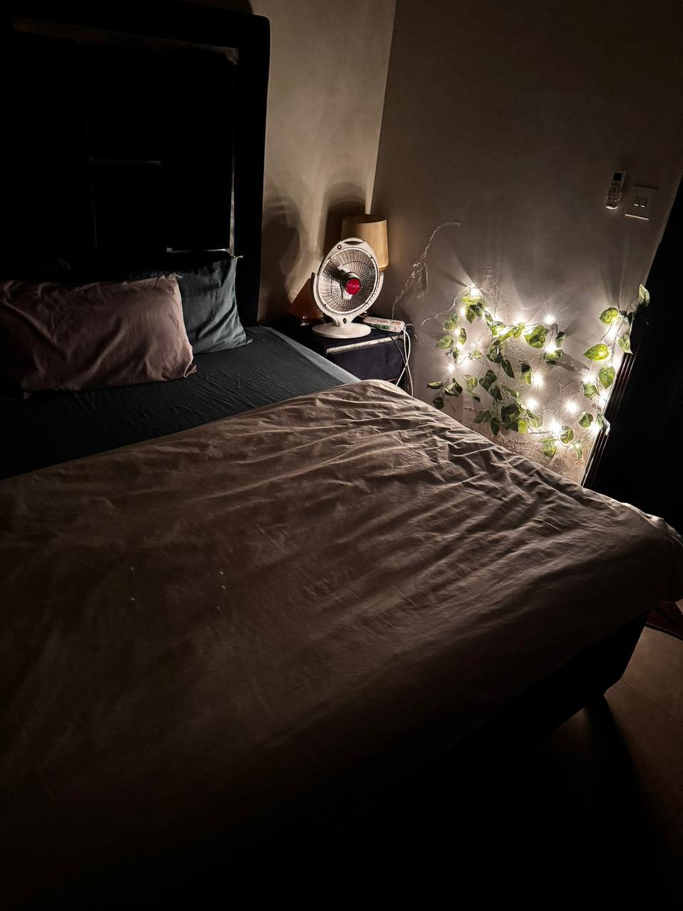 Bedroom with two beds and warm string lighting in the Aangan three-bedroom apartment in E-11, Islamabad