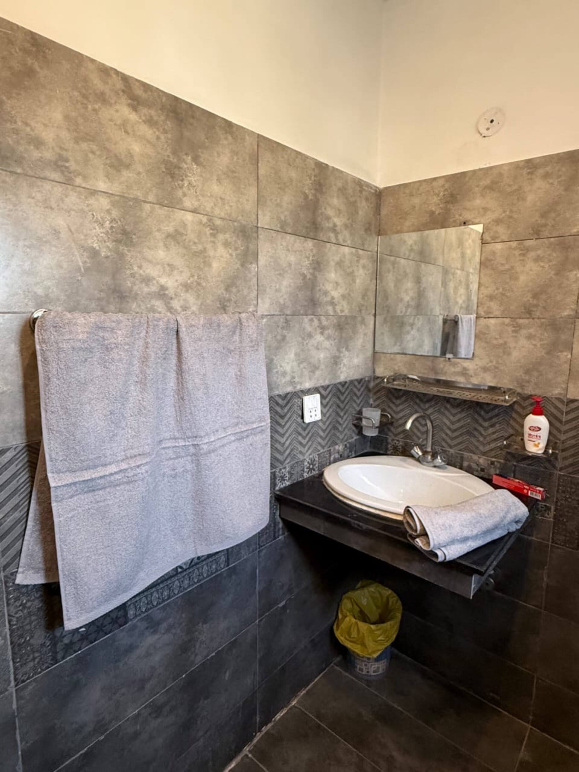 Bathroom vanity with fresh towels and toiletries in The Amber Haven, the Aangan one-bedroom apartment facing Grand Jamia Mosque in Bahria Town Lahore