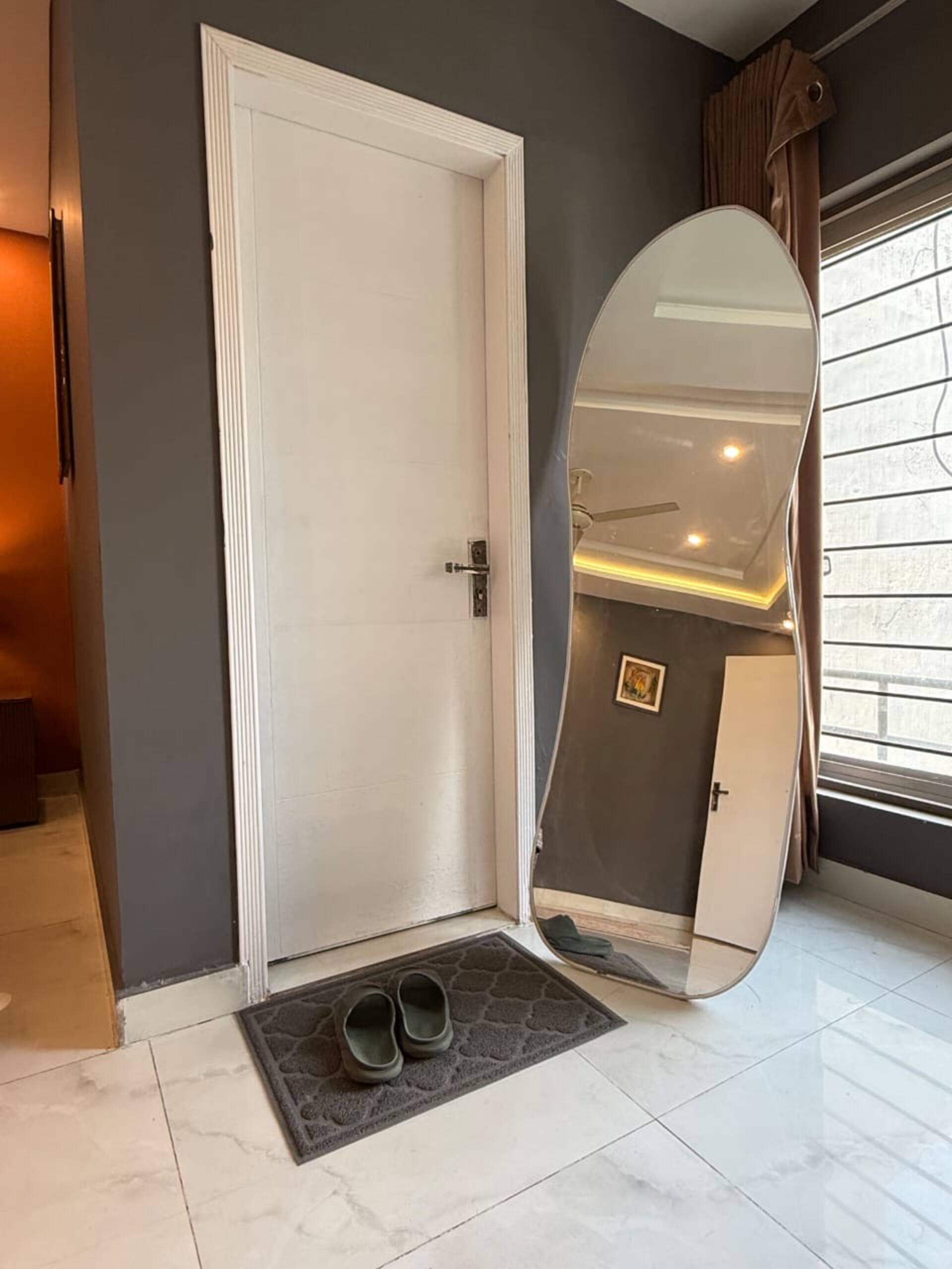 Full-length mirror beside the entrance of The Amber Haven, the Aangan one-bedroom apartment facing Grand Jamia Mosque in Bahria Town Lahore