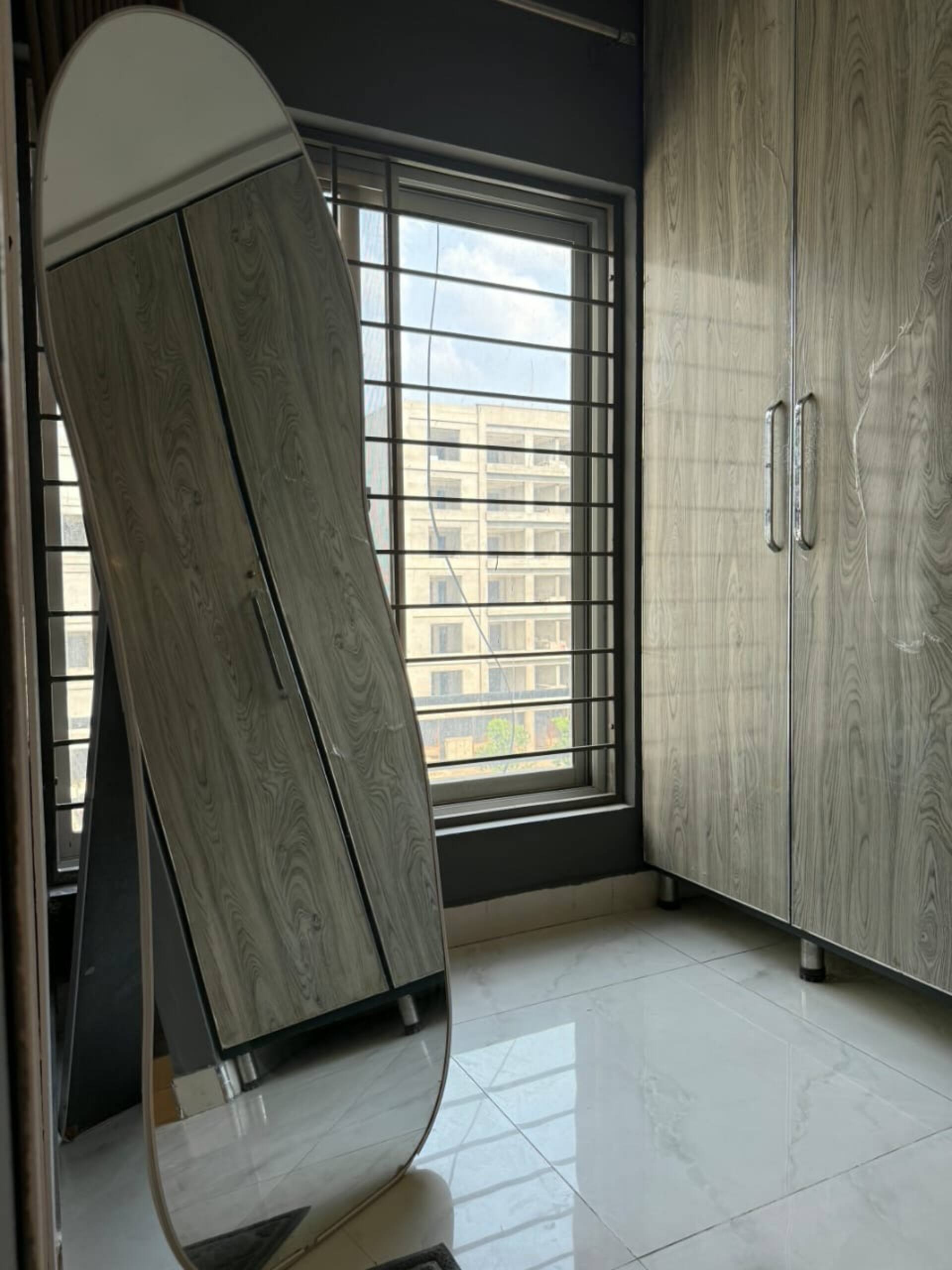 Wardrobe with clothing storage and a full-length mirror in The Amber Haven, the Aangan one-bedroom apartment facing Grand Jamia Mosque in Bahria Town Lahore
