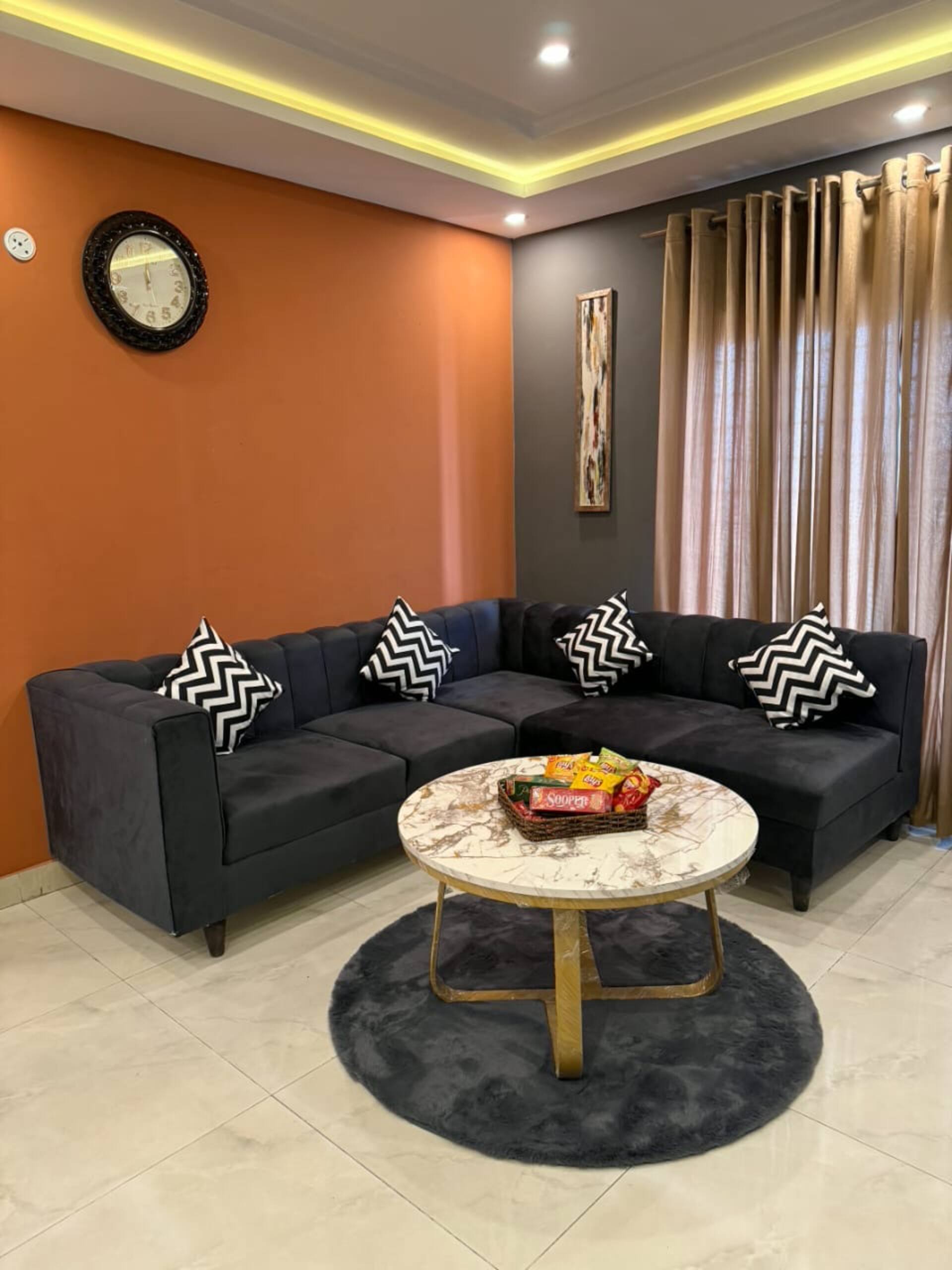 Sofa seating and coffee table in the living area of The Amber Haven, the Aangan one-bedroom apartment facing Grand Jamia Mosque in Bahria Town Lahore
