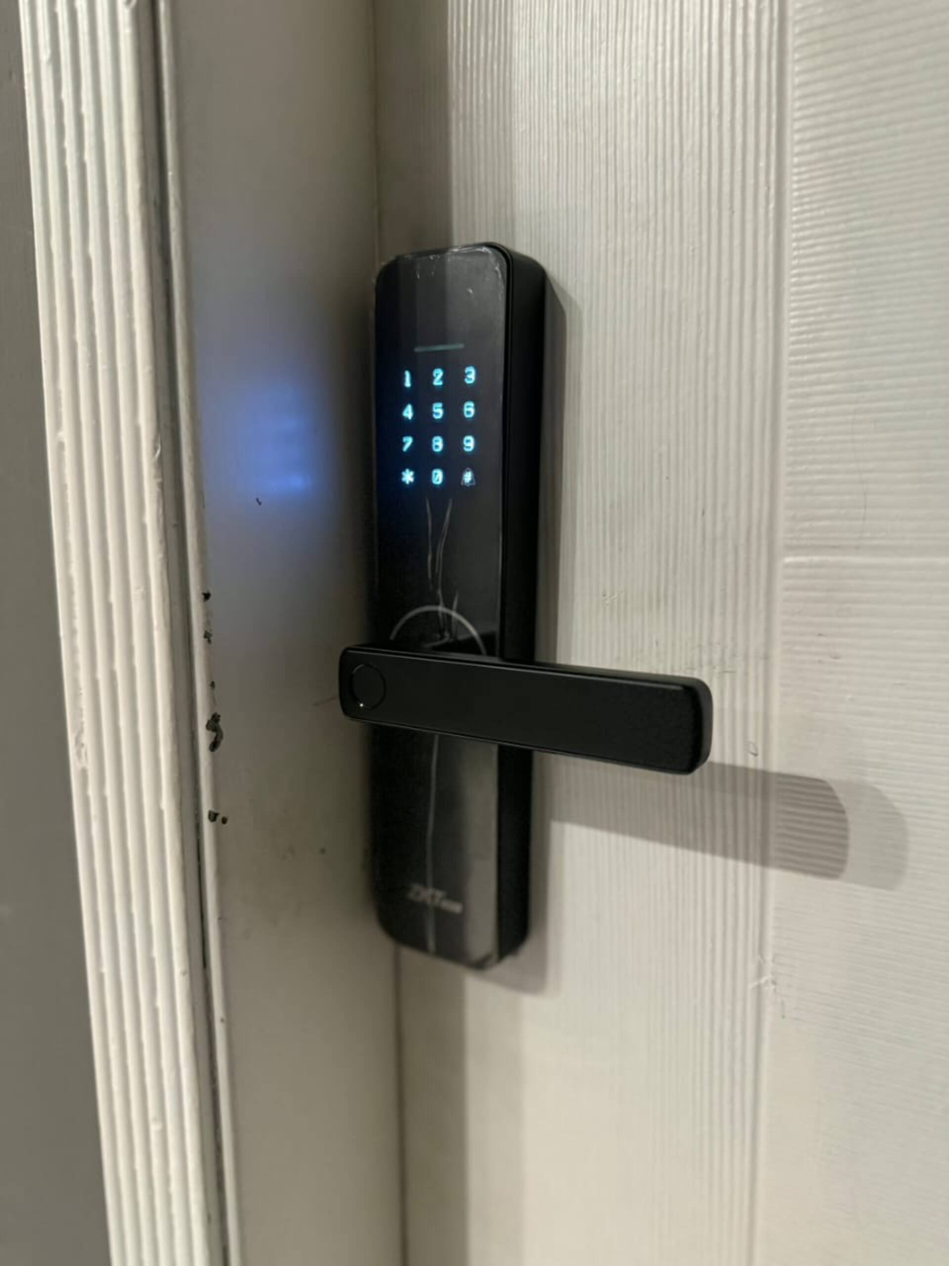 Smart lock on the front door for self check-in at The Amber Haven, the Aangan one-bedroom apartment facing Grand Jamia Mosque in Bahria Town Lahore