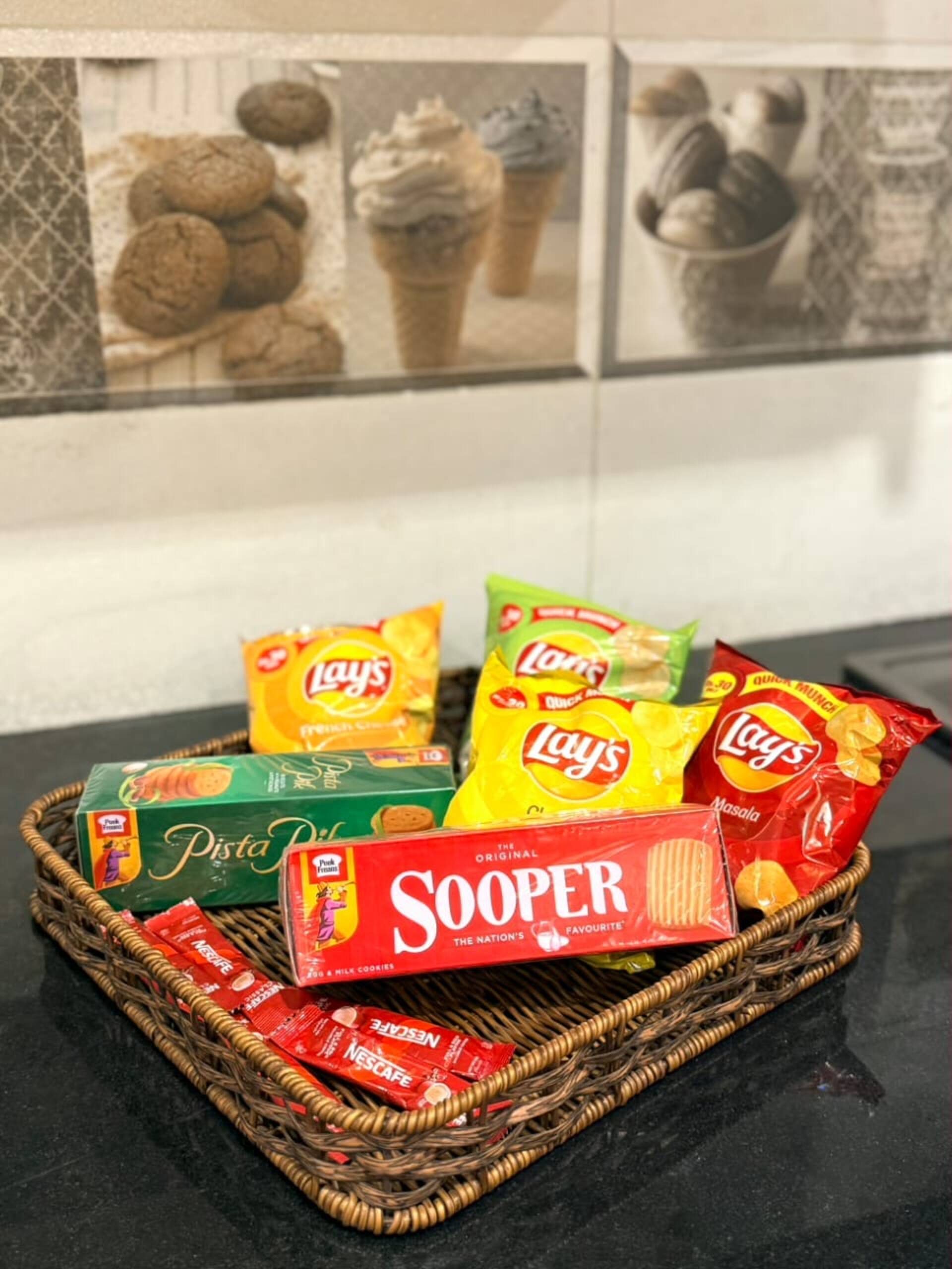 Basket of complimentary welcome snacks in The Amber Haven, the Aangan one-bedroom apartment facing Grand Jamia Mosque in Bahria Town Lahore