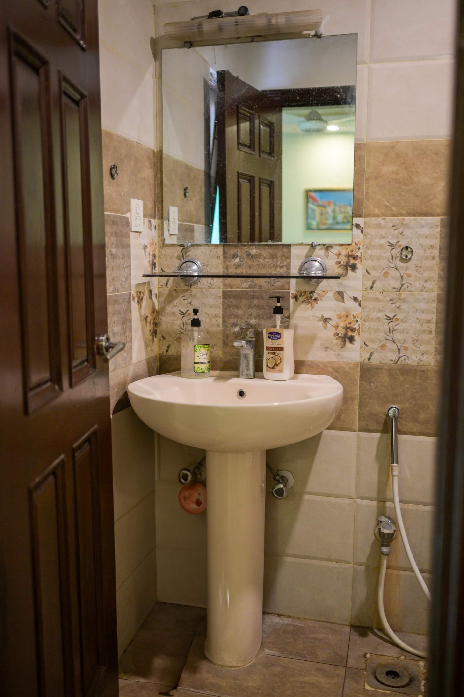 Washbasin and mirror in a bathroom of the Aangan three-bedroom gaming suite in Apollo Tower, E-11 Islamabad