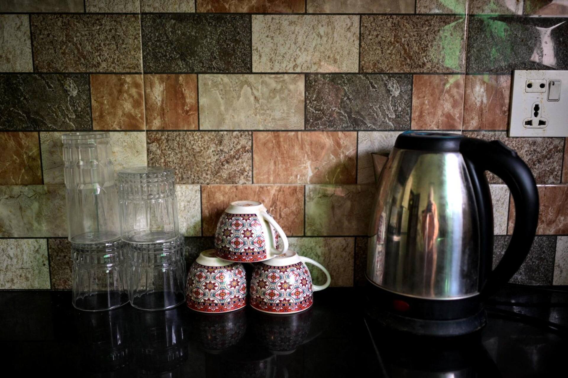 Electric kettle, cups and glasses on the kitchen counter of the Aangan three-bedroom gaming suite in Apollo Tower, E-11 Islamabad