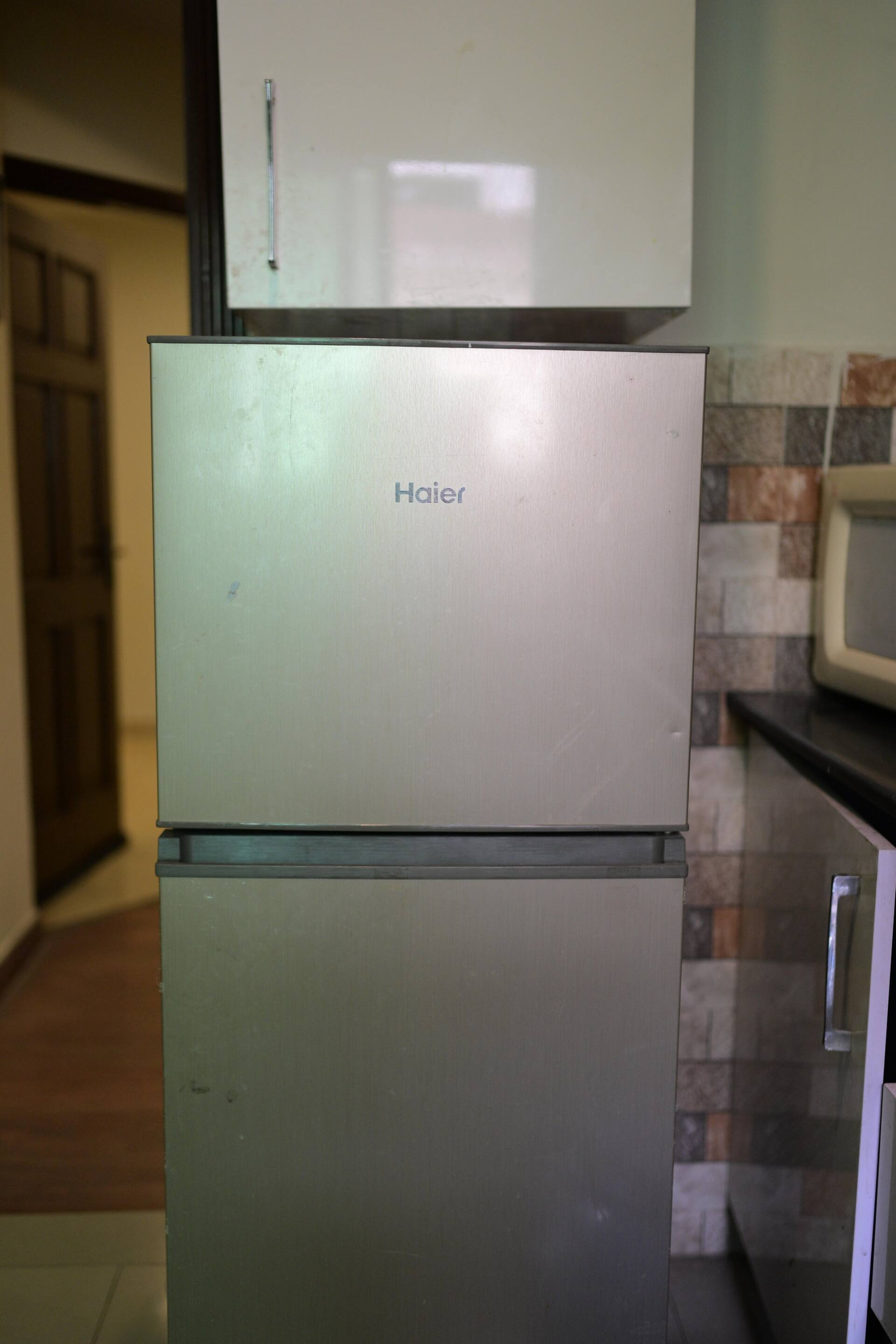 Refrigerator with freezer in the kitchen of the Aangan three-bedroom gaming suite in Apollo Tower, E-11 Islamabad
