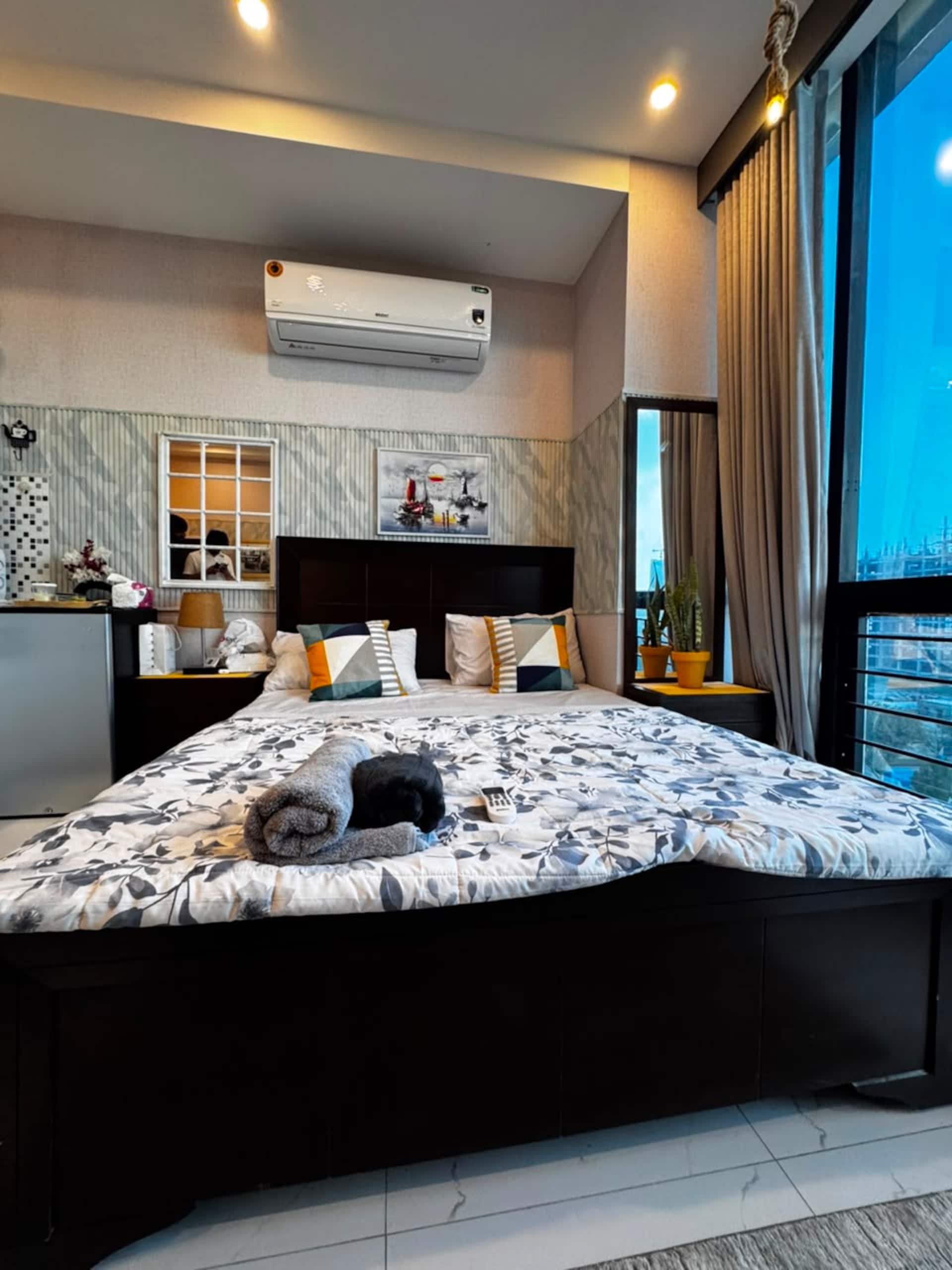 Bed prepared with folded towels before arrival at the Aangan studio apartment near Islamabad International Airport