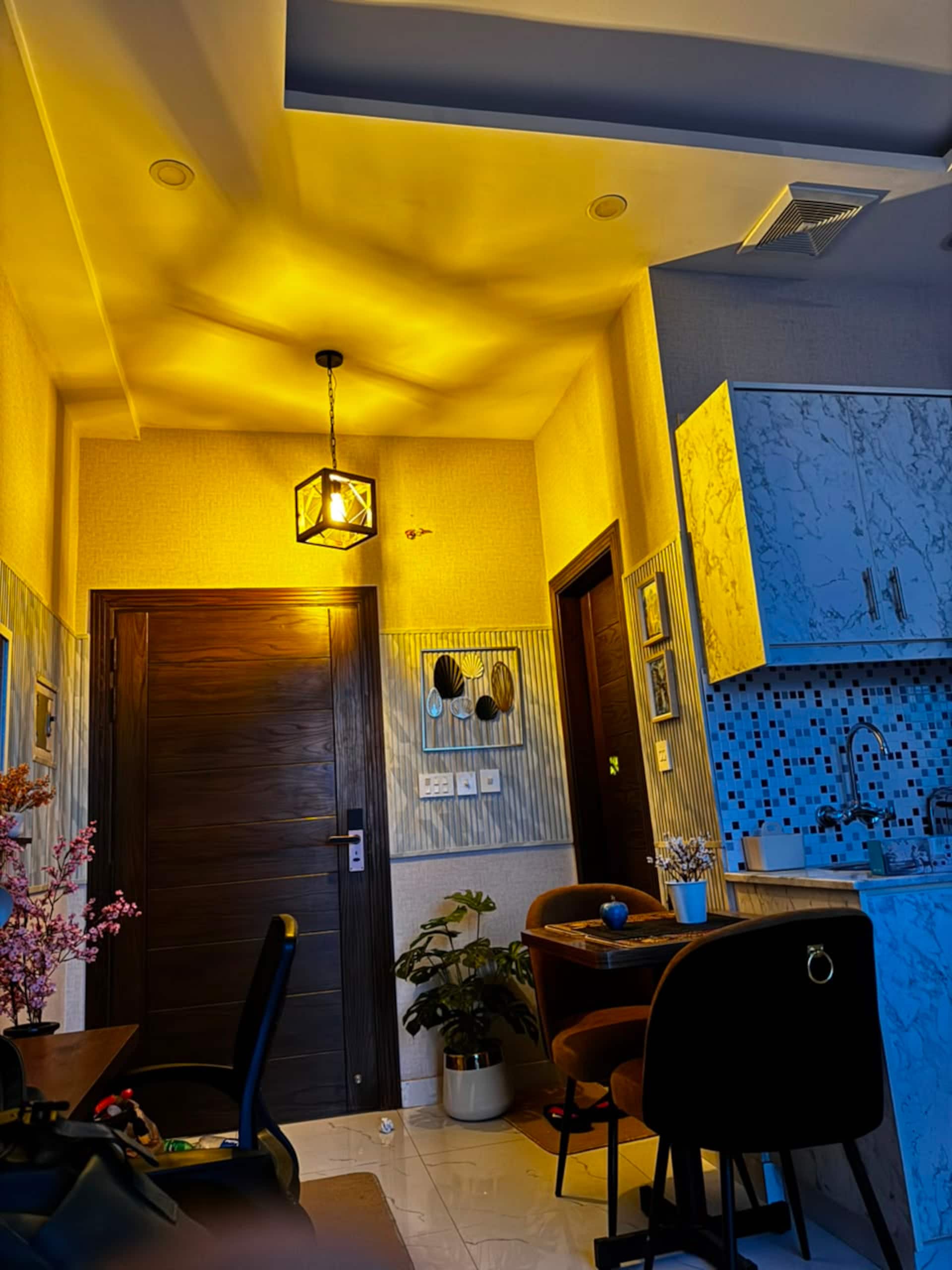 Entrance door and small dining table inside the Aangan studio apartment near Islamabad International Airport