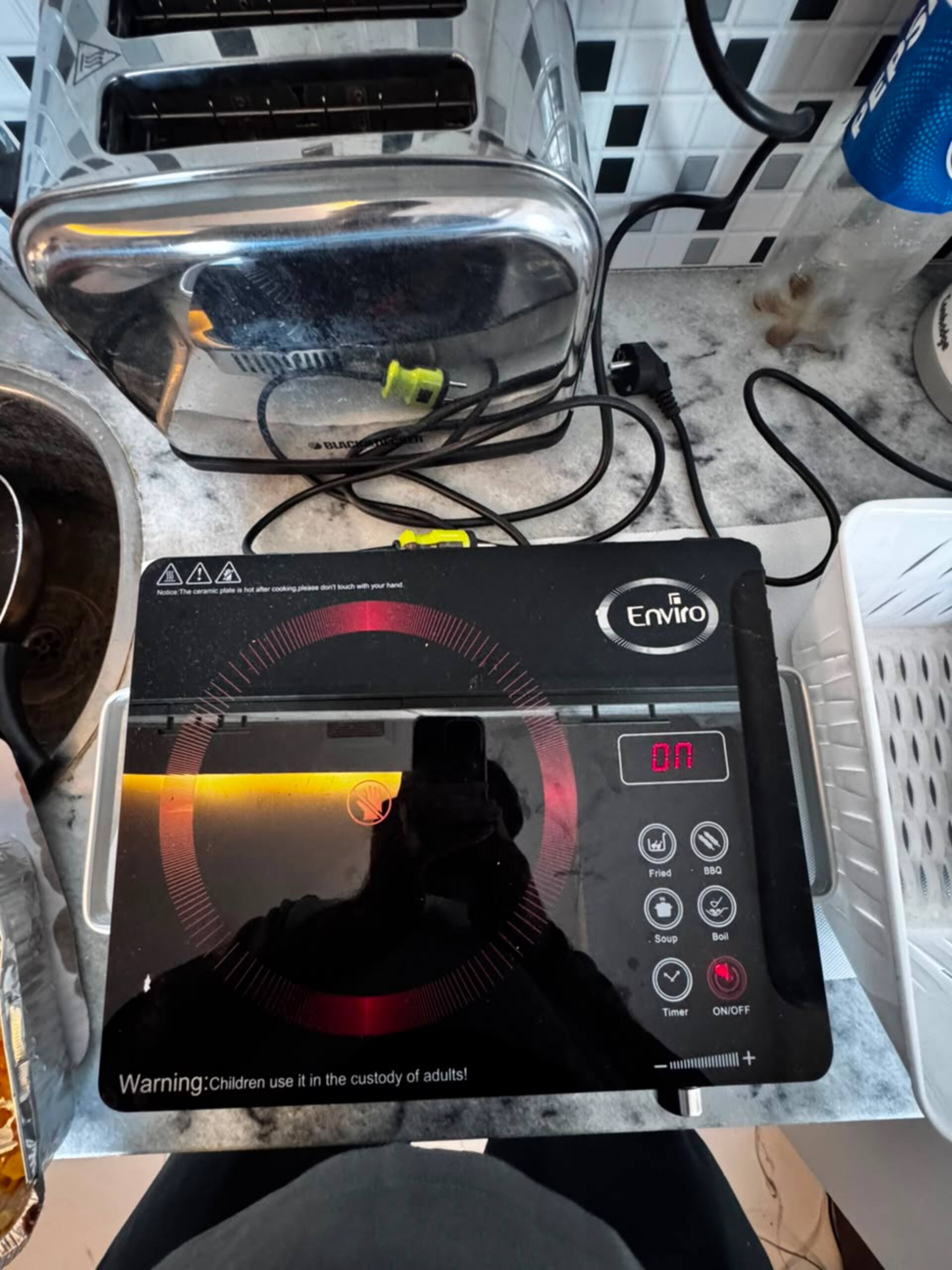 Induction cooktop in the kitchenette of the Aangan studio apartment near Islamabad International Airport