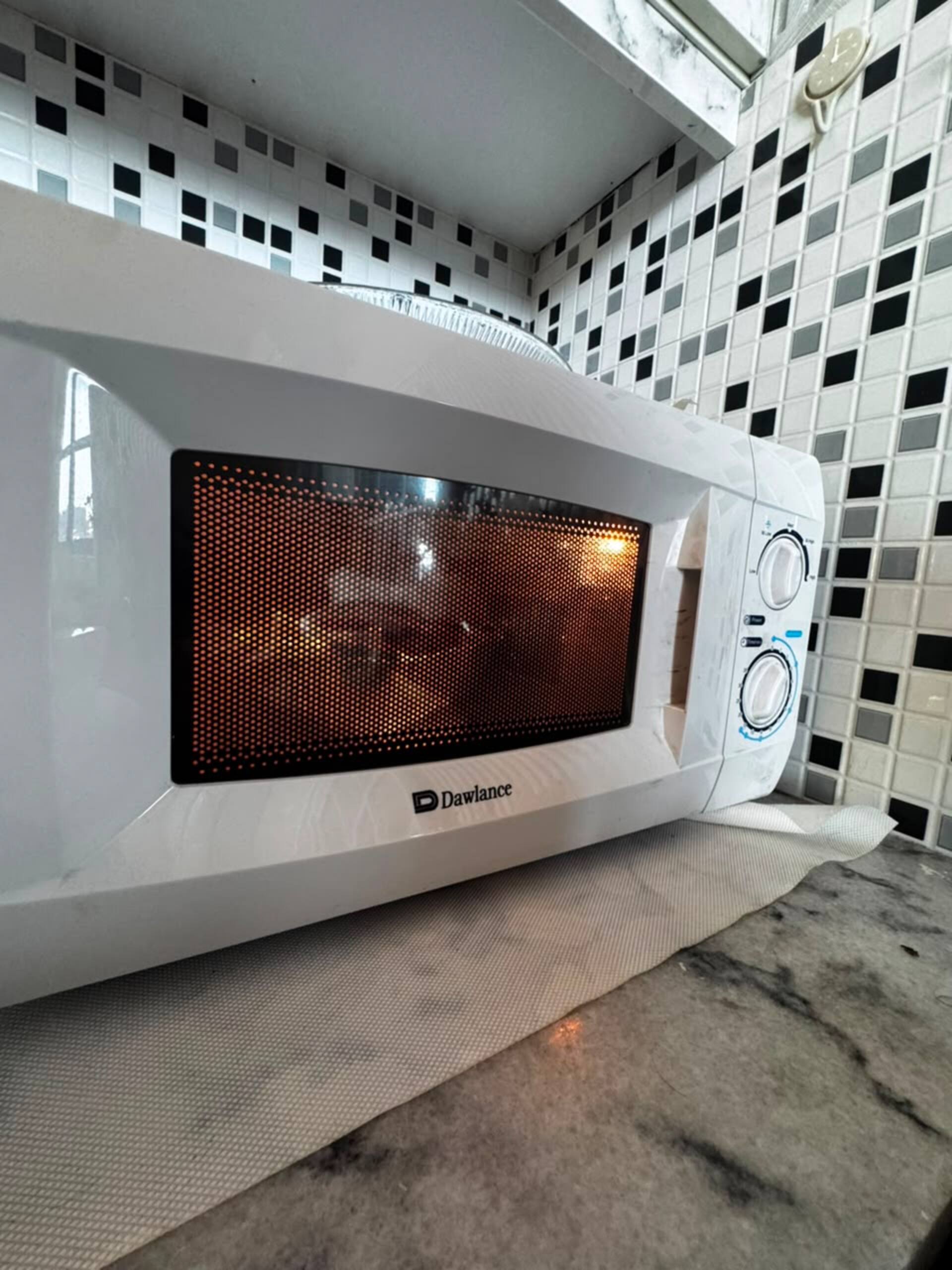 Microwave on the kitchenette counter in the Aangan studio apartment near Islamabad International Airport