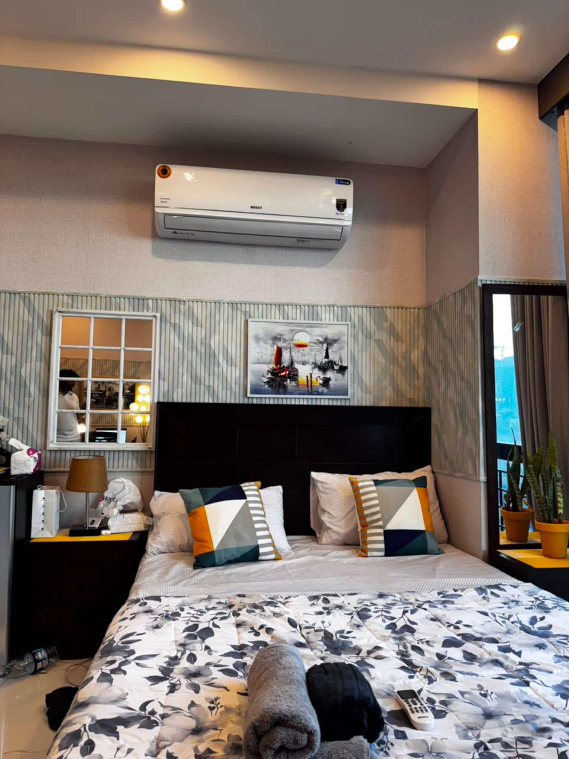 Queen bed with air conditioning above in the Aangan studio apartment near Islamabad International Airport