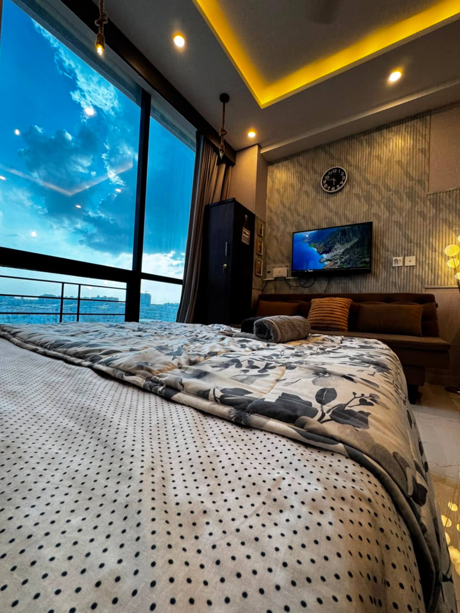 Queen bed facing the window and city view in the Aangan studio apartment near Islamabad International Airport