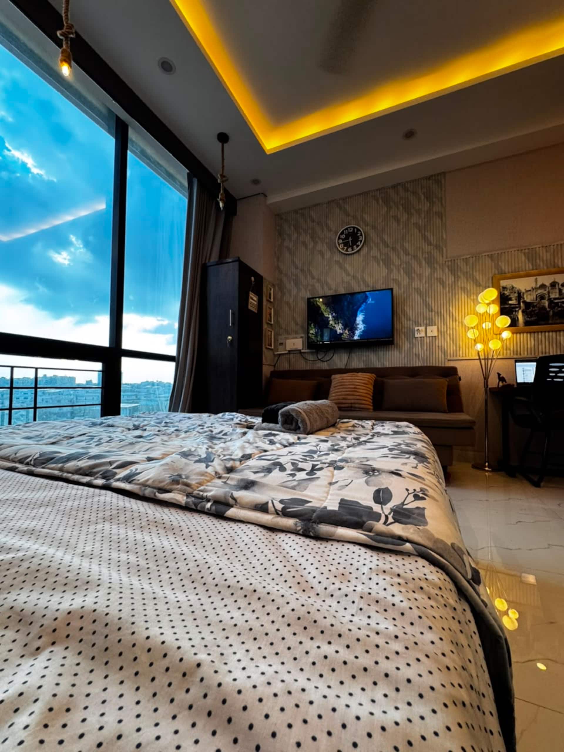Queen bed with fresh linen beside the window in the Aangan studio apartment near Islamabad International Airport