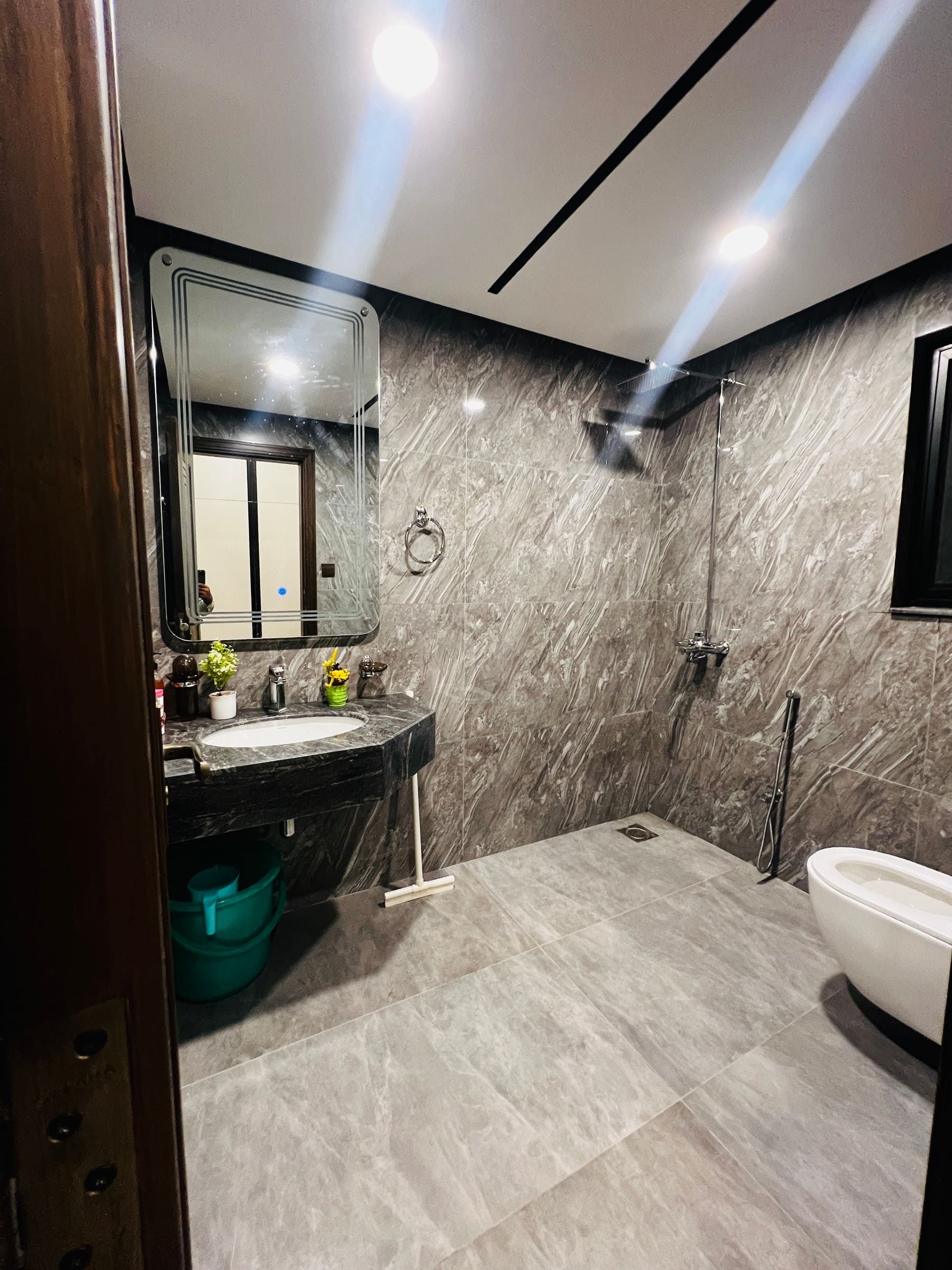Marble bathroom with a shower area in the 3-bedroom Aangan apartment in Zeta Mall, Islamabad