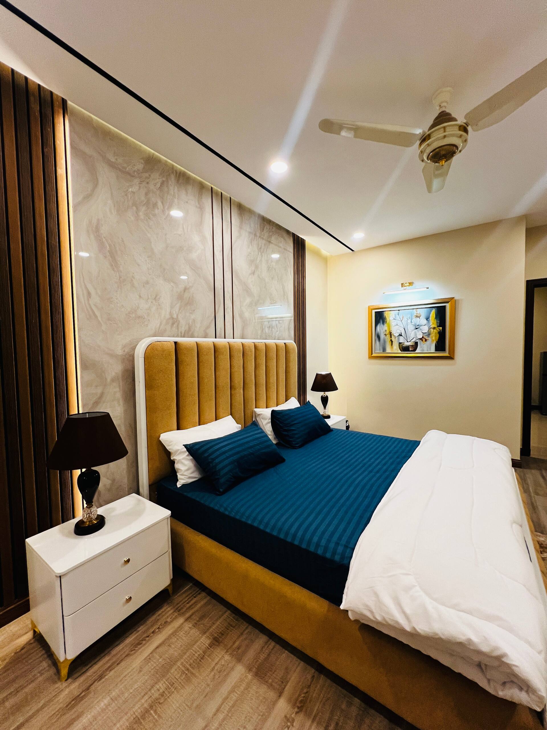 King bedroom with bedside tables and ceiling fan in the 3-bedroom Aangan apartment in Zeta Mall, Islamabad