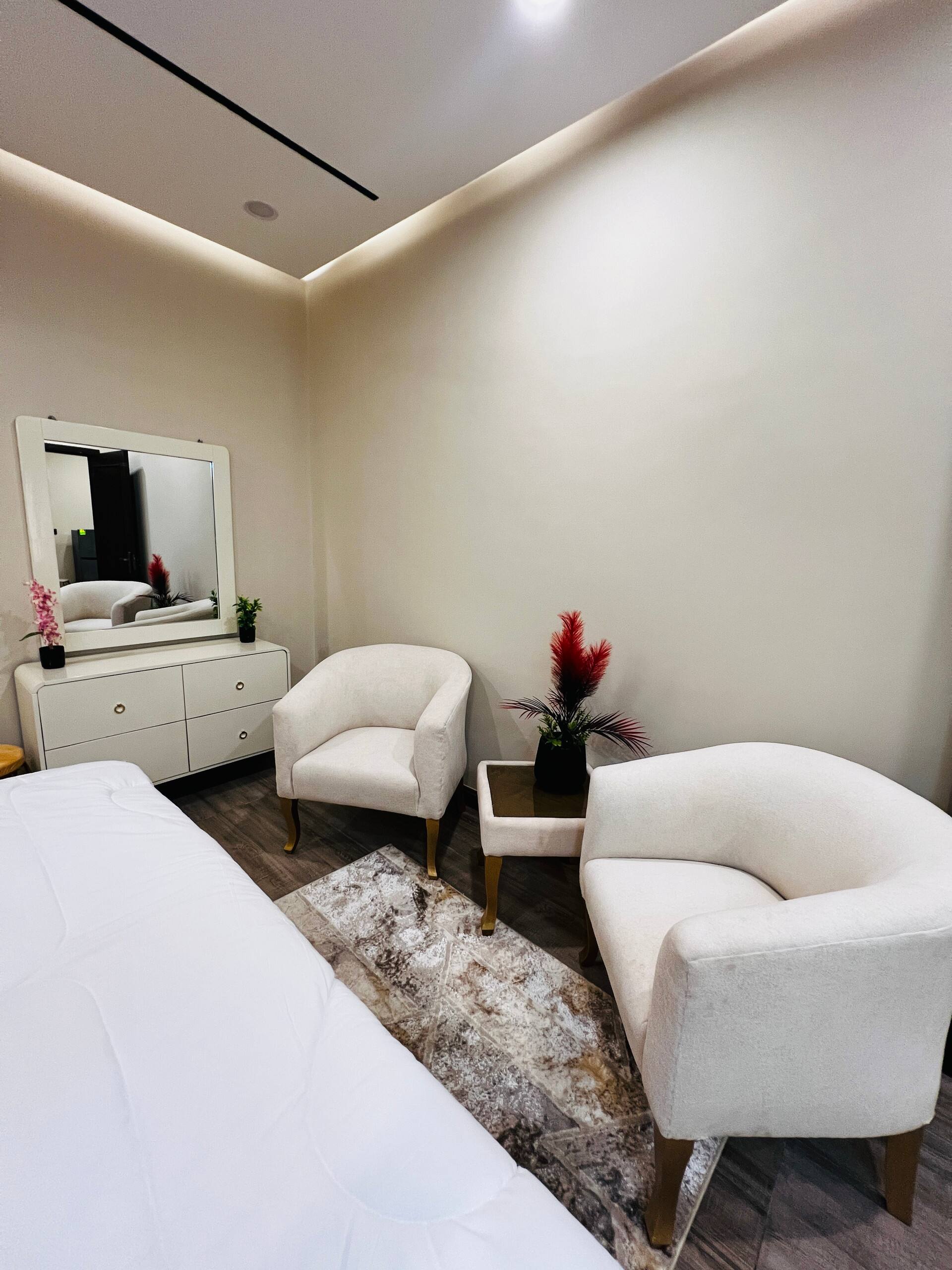 Third bedroom with seating beside the bed in the 3-bedroom Aangan apartment in Zeta Mall, Islamabad