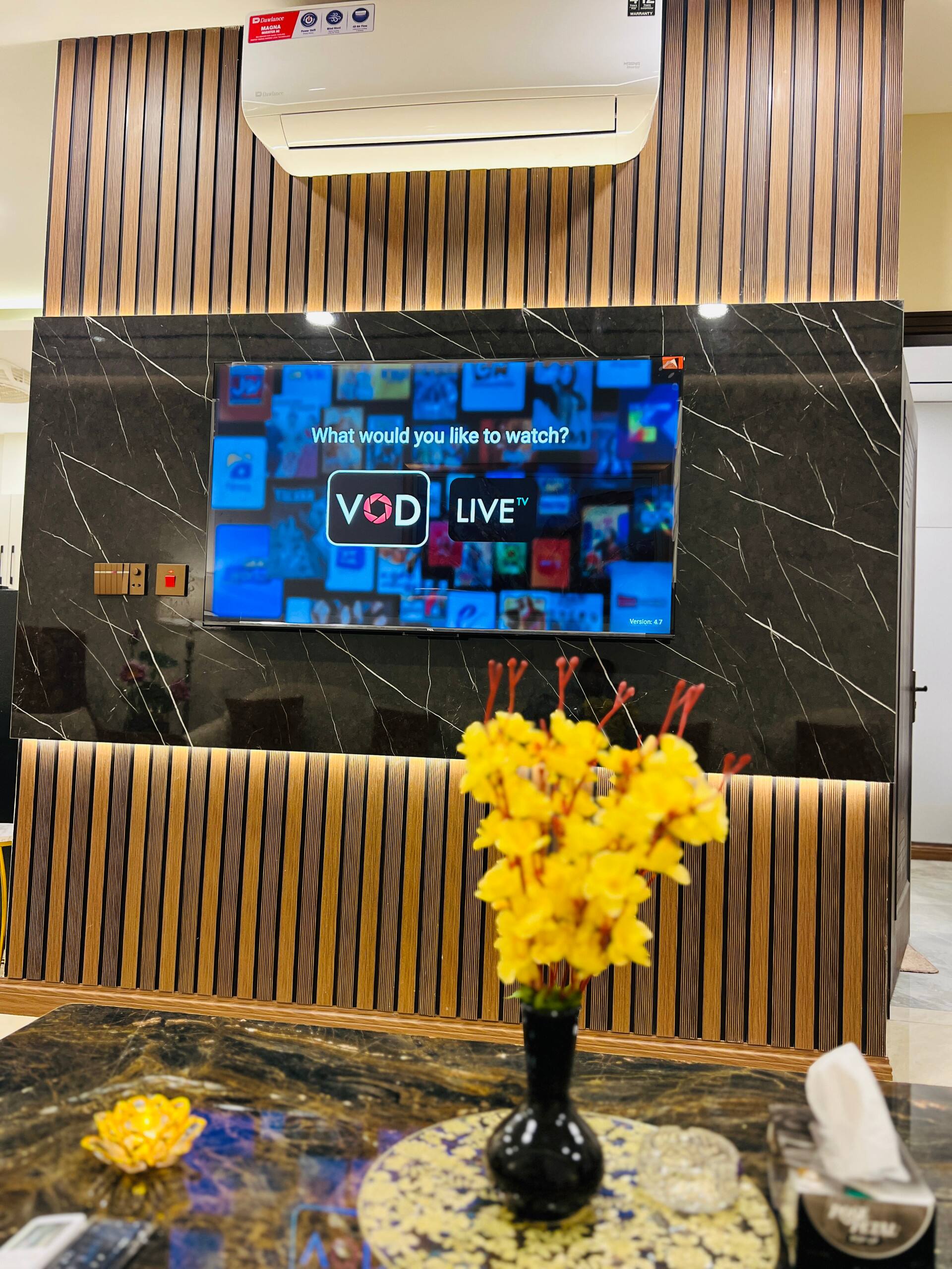 Marble media wall with a smart TV in the living room of the 3-bedroom Aangan apartment in Zeta Mall, Islamabad