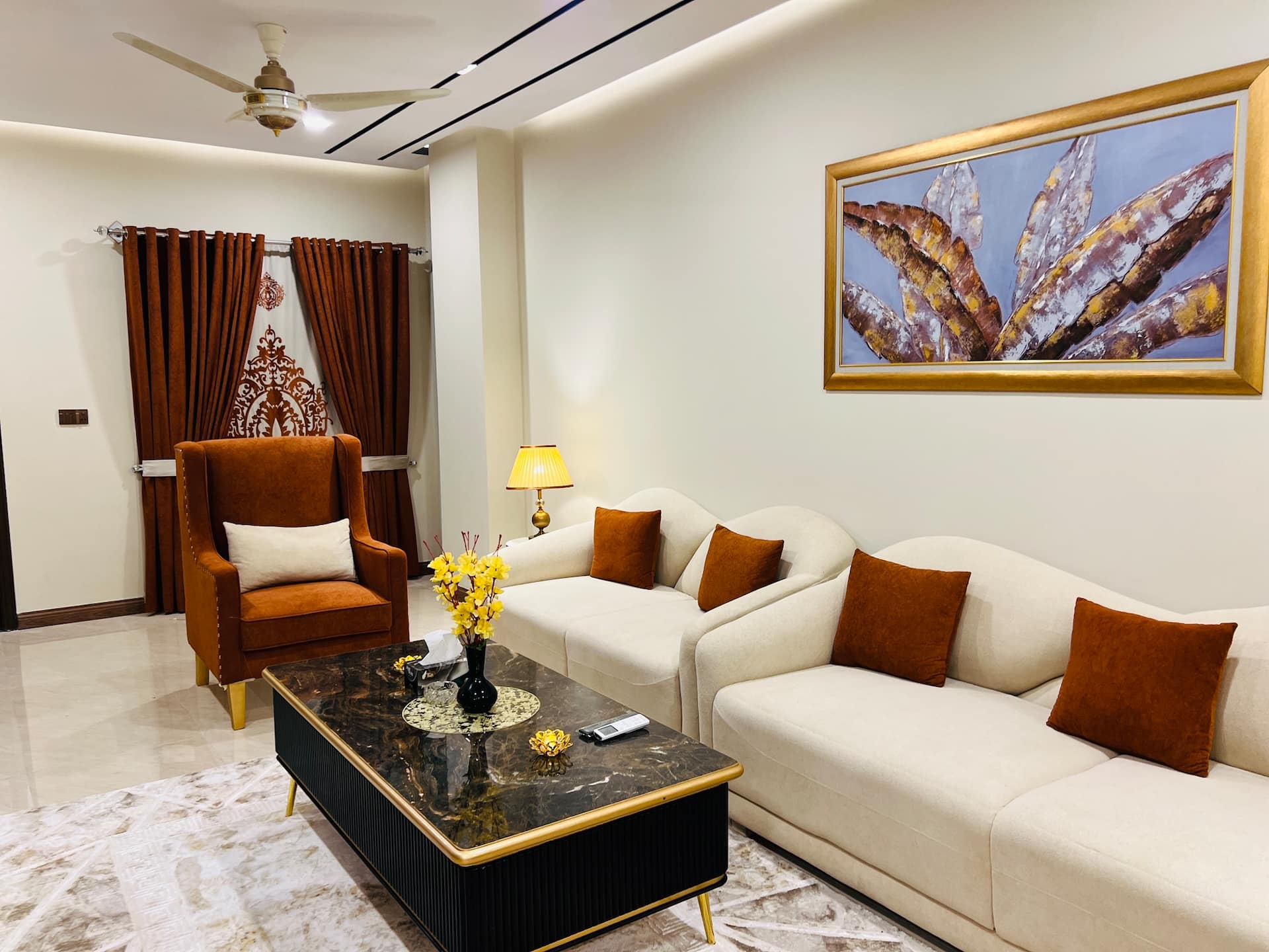 Living room with sofas, armchairs and a marble coffee table in the 3-bedroom Aangan apartment in Zeta Mall, Islamabad